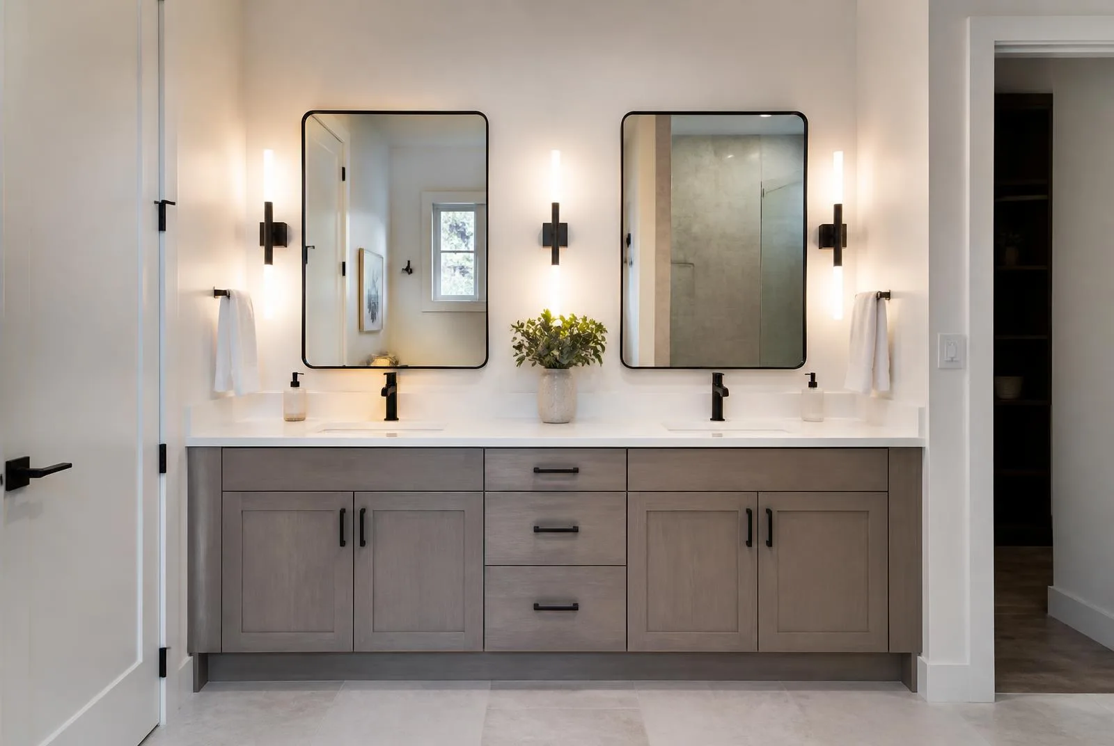 Remodeled bathroom with double vanity, quartz top, and modern sconce lighting