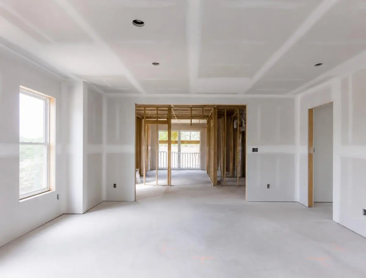 New stud framing and hung drywall ready for finishing inside a home remodel
